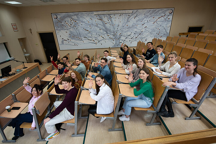 Studenci w ławkach na sali.