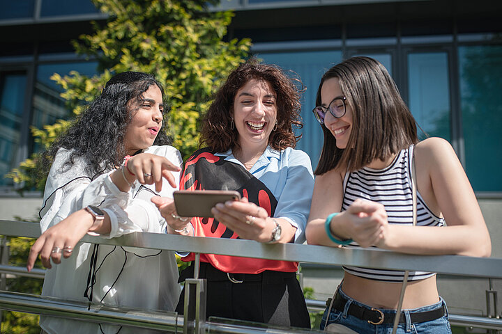Studentki czytają porady na ekranie telefonu